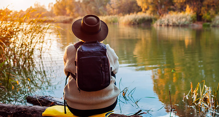 A person next to a river in a moment of reflection